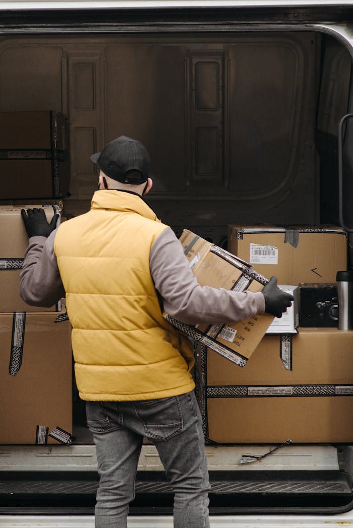 Deliveryman organizing packages into a van for distribution.